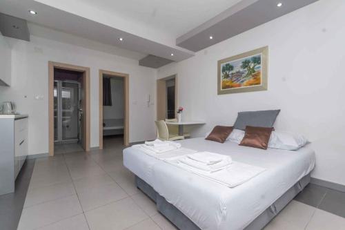 奈維斯的住宿－Apartments in Njivice/Insel Krk 13314，一间带白色大床的卧室和一间厨房