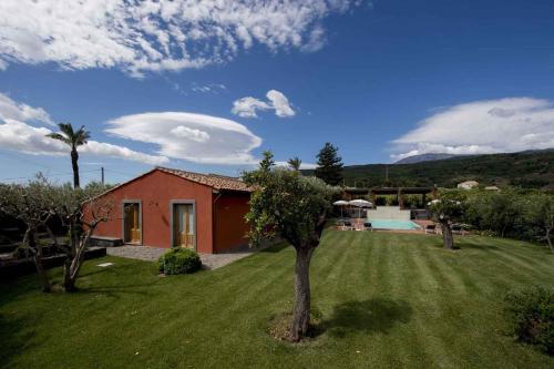 una casa con un patio de césped con un árbol en Apartment in Linguaglossa/Sizilien 38022, en Linguaglossa