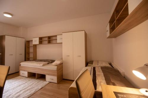 a bedroom with two beds and a desk and a table at MARIBOR CITY CENTER MINIDORM APARTMENT in Maribor
