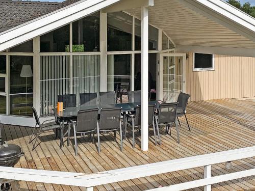 a screened in deck with a table and chairs at 10 person holiday home in V ggerl se in Marielyst