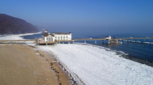 a building on the beach next to a pier at Ferienwohnung "Bellevue" in Sellin auf Rügen in Ostseebad Sellin