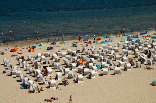 a crowd of people on a beach with chairs and umbrellas at Ferienwohnung "Bellevue" in Sellin auf Rügen in Ostseebad Sellin