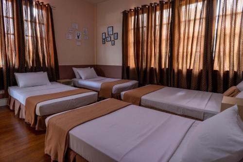 a hospital room with three beds and windows at Old Orangewood Bed & Breakfast in Baguio