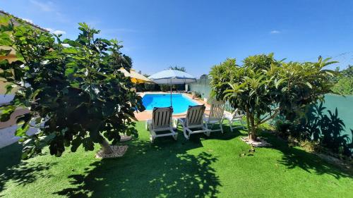 a yard with two chairs and a swimming pool at Casa da Vinha Azeitão in Azeitao