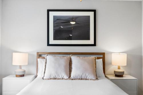 a bedroom with a white bed with two lamps at Kasa Delray Beach South Florida in Delray Beach
