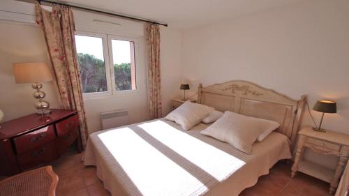 une chambre avec un lit et une fenêtre dans l'établissement Sainte-Maxime - 3 bedroom apartment, air conditioned, outdoor terrace, swimming pool, à Sainte-Maxime