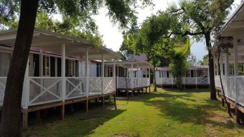 una fila di cottage bianchi con alberi nel cortile di Mobilehomes in Cavallino-Treporti 33773 a Cavallino-Treporti