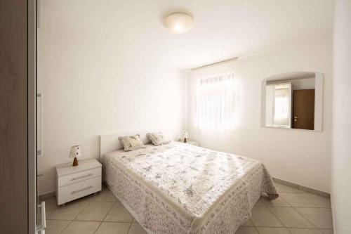 a white bedroom with a bed and a mirror at Apartment in Ravni/Istrien 8872 in Ravni