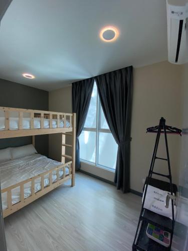 a bedroom with bunk beds and a ladder in front of a window at JY Vacation Home New & Modern Suite Infinity pool-Sutera Avenue in Kota Kinabalu