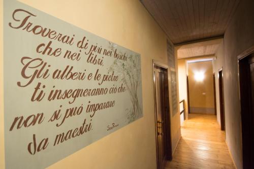 a sign on the wall of a hallway at Eremo Montemezzano in Pratovecchio