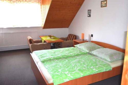 a bedroom with a large bed and a table at Holiday home in Balatonkeresztur 19234 in Balatonkeresztúr