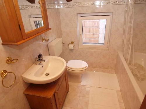 a bathroom with a sink and a toilet and a window at Holiday home in Veli Losinj 36387 in Veli Lošinj