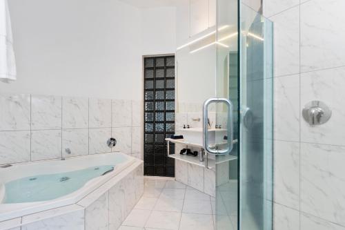 a bathroom with a tub and a glass shower at The Tauranga on the Waterfront in Tauranga
