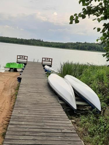 two boats sitting on a dock next to a lake at Pod żurawiem Szwałk 1 in Szwalk