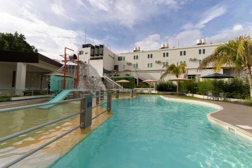 a swimming pool with a water slide in front of a building at La Terraza Hotel in Jalpan