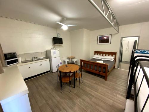 a room with a kitchen and a table and a bed at Bundaberg Park Village in Bundaberg