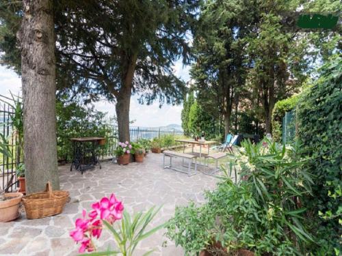 a patio with a table and benches and flowers at Apartment in Bagno a Ripoli/Toskana 23871 in Villamagna