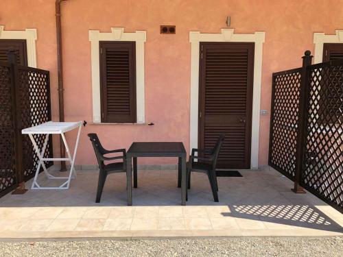 a table and two chairs in front of a pink building at Apartment in Palmi/Kalabrien 21007 in Palmi