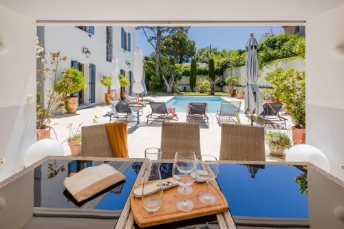 une terrasse avec une table, des chaises et une piscine dans l'établissement SERRENDY Villa in Cap dAntibes near beaches, à Antibes