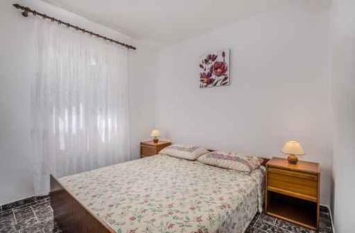 1 dormitorio con 1 cama, 2 mesitas de noche y 2 lámparas en Apartment in Klimno/Insel Krk 14302, en Klimno