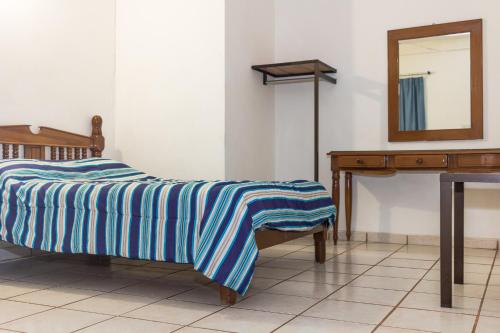 a bedroom with a bed and a mirror and a table at Hotel Saja in Ciudad Valles