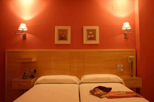 uma cama num quarto com uma parede vermelha em Sol Mediterraneo em Archena