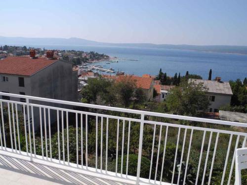 a balcony with a view of a town and the water at Apartment in Selce 5818 in Selce