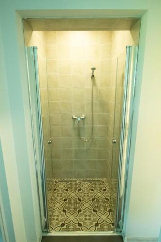 a shower with a glass door in a bathroom at King Kong Kapitány Vendégház in Fonyód