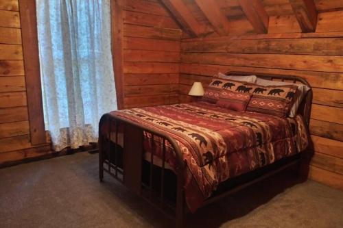 een slaapkamer met een bed in een blokhut bij Hoot Nanny's Rustic Cabin on Mossy Creek in Cleveland