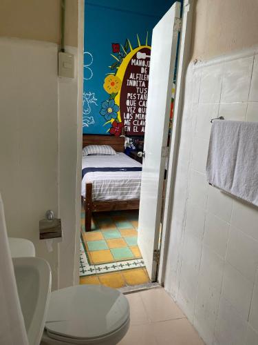 a bathroom with a small bedroom with a bed in it at Chuchumbé Hotel & Hostal in Veracruz