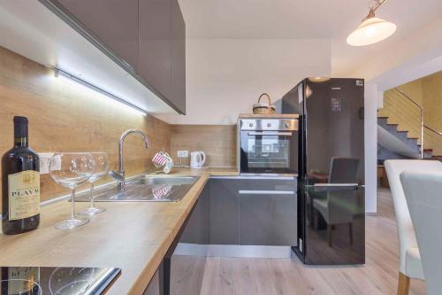 a kitchen with a refrigerator and a counter with wine glasses at Apartments in Peroj/Istrien 34288 in Peroj