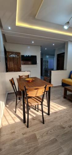 a wooden table and chairs in a living room at Bonne étoile Imsouane in Imsouane