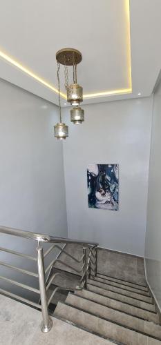 a staircase with a glass table and a chandelier at Bonne étoile Imsouane in Imsouane