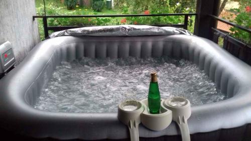 a hot tub with a bottle and two cups in it at Holiday home in Turke/Gorski Kotar 35160 in Turke