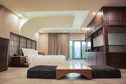 a hotel room with a bed and a table at OHYA Chain Boutique Motel-Xinying in Xinying