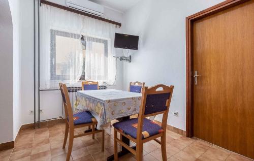 een eettafel en stoelen met een tafel en een raam bij Apartments in Porec/Istrien 27760 in Poreč