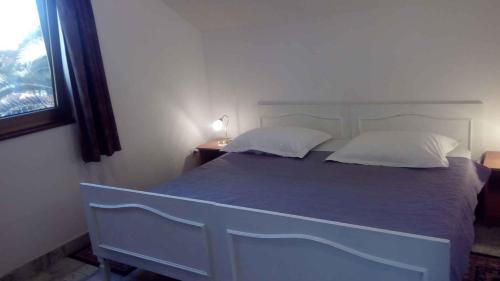 a bedroom with a blue bed and a window at Apartments in Mali Losinj 14951 in Mali Lošinj