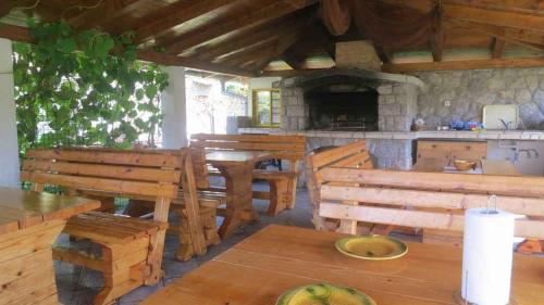 ein Restaurant mit Holztischen und Bänken in einem Zimmer in der Unterkunft Apartments in Vantacici - Insel Krk 13154 in Vantačići
