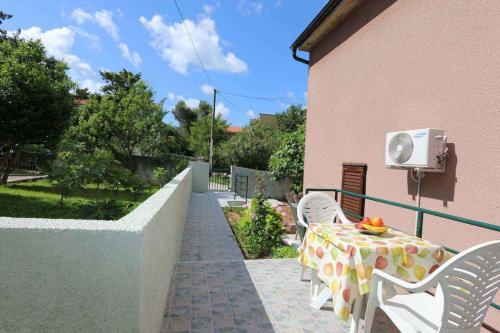 patio ze stołem i krzesłami oraz budynek w obiekcie Apartment in Silo/Insel Krk 13583 w mieście Šilo