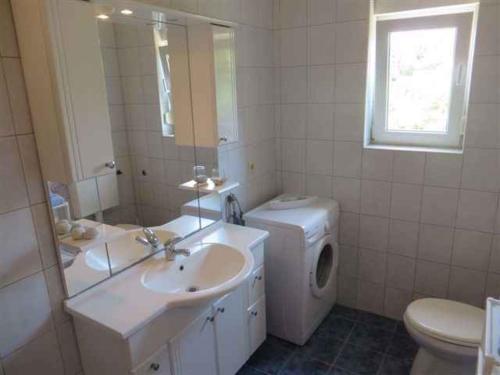 a bathroom with a toilet sink and a washing machine at Apartment in Klimno/Insel Krk 12479 in Klimno