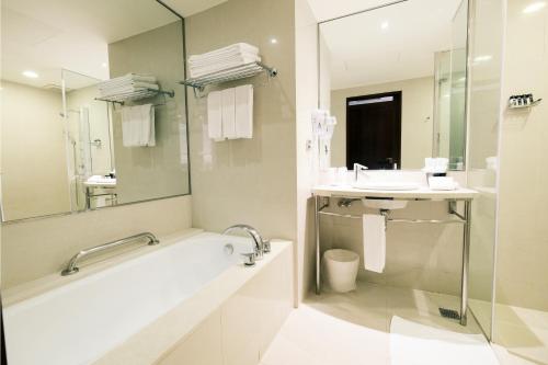 a bathroom with a tub and a sink and a mirror at Hotel Del Lago in Yuchi
