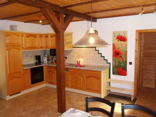 - une cuisine avec des placards en bois, une table et des chaises dans l'établissement Landferienhaus Havelland in Kloster Lehnin, à Trechwitz