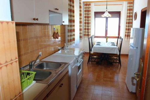 a kitchen with a sink and a table with a dining room at Three-Bedroom Apartment in Novi Vinodolski I in Povile
