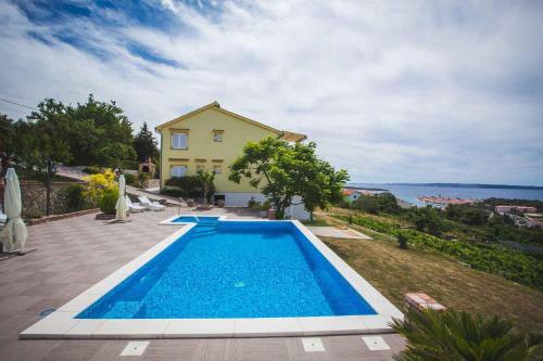 a swimming pool in front of a house at Apartments in Rab/Insel Rab 16117 in Mundanije