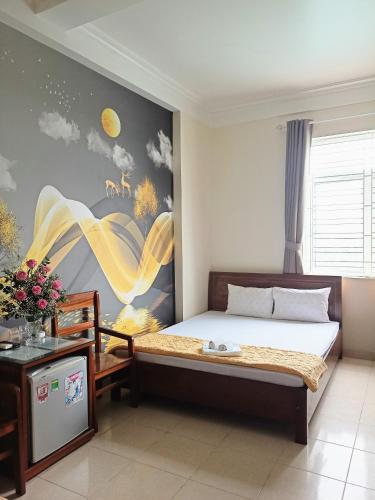 a bedroom with a bed and a painting on the wall at Tay Dai Duong Guesthouse in Hai Phong