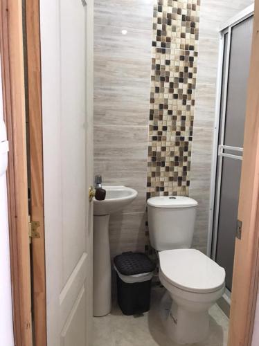 a bathroom with a toilet and a sink at Hermosa Casa en el centro de Santa Rosa de Cabal, sobre vía principal a 3 cuadras de la Plaza in Santa Rosa de Cabal