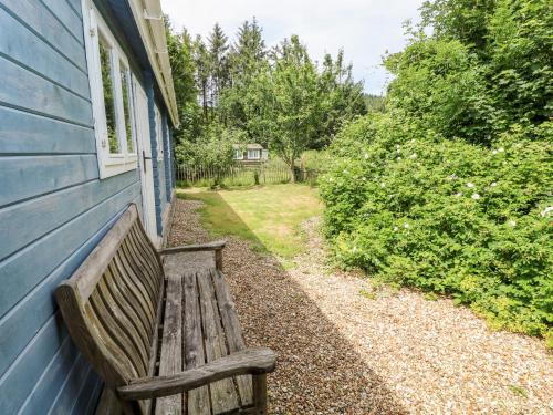 a wooden bench sitting outside of a blue building at The Beach Shack in Carmarthen