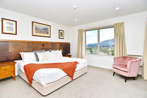 um quarto com uma cama, uma cadeira e uma janela em High Country Villa 250 - Terrace Downs em Windwhistle