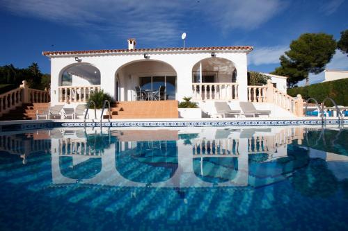 uma villa com piscina em frente a uma casa em Villa Robin - Costa CarpeDiem em Calpe