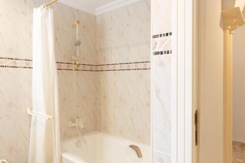a bathroom with a shower and a bath tub with a shower at Apartamento Joya I - Costa CarpeDiem in Calpe